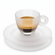 A clear glass espresso cup with a matching white saucer, filled with layered coffee showing dark espresso, crema, and a light tan layer, isolated on a white background.