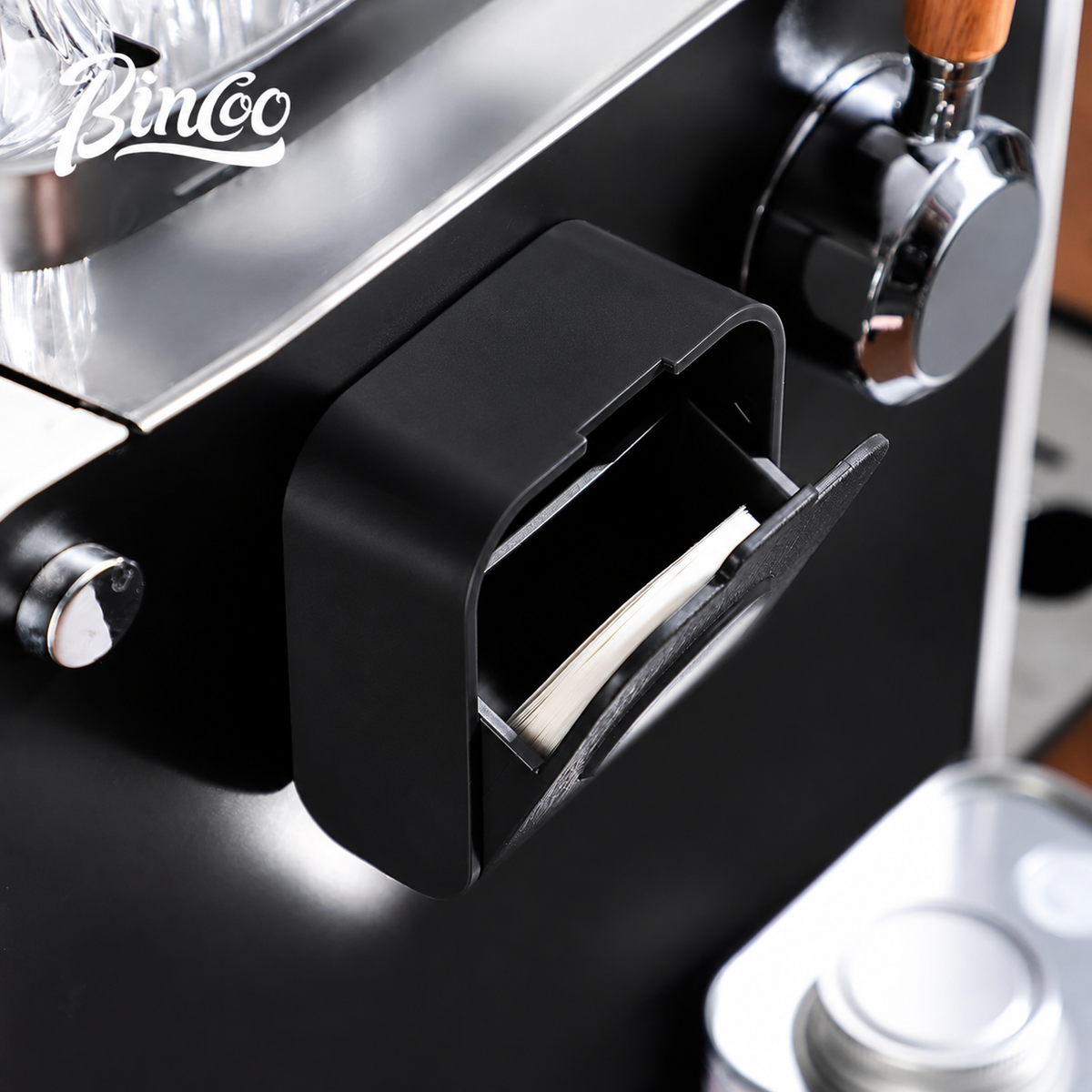 Hand pulling a round paper filter from the Bincoo holder
